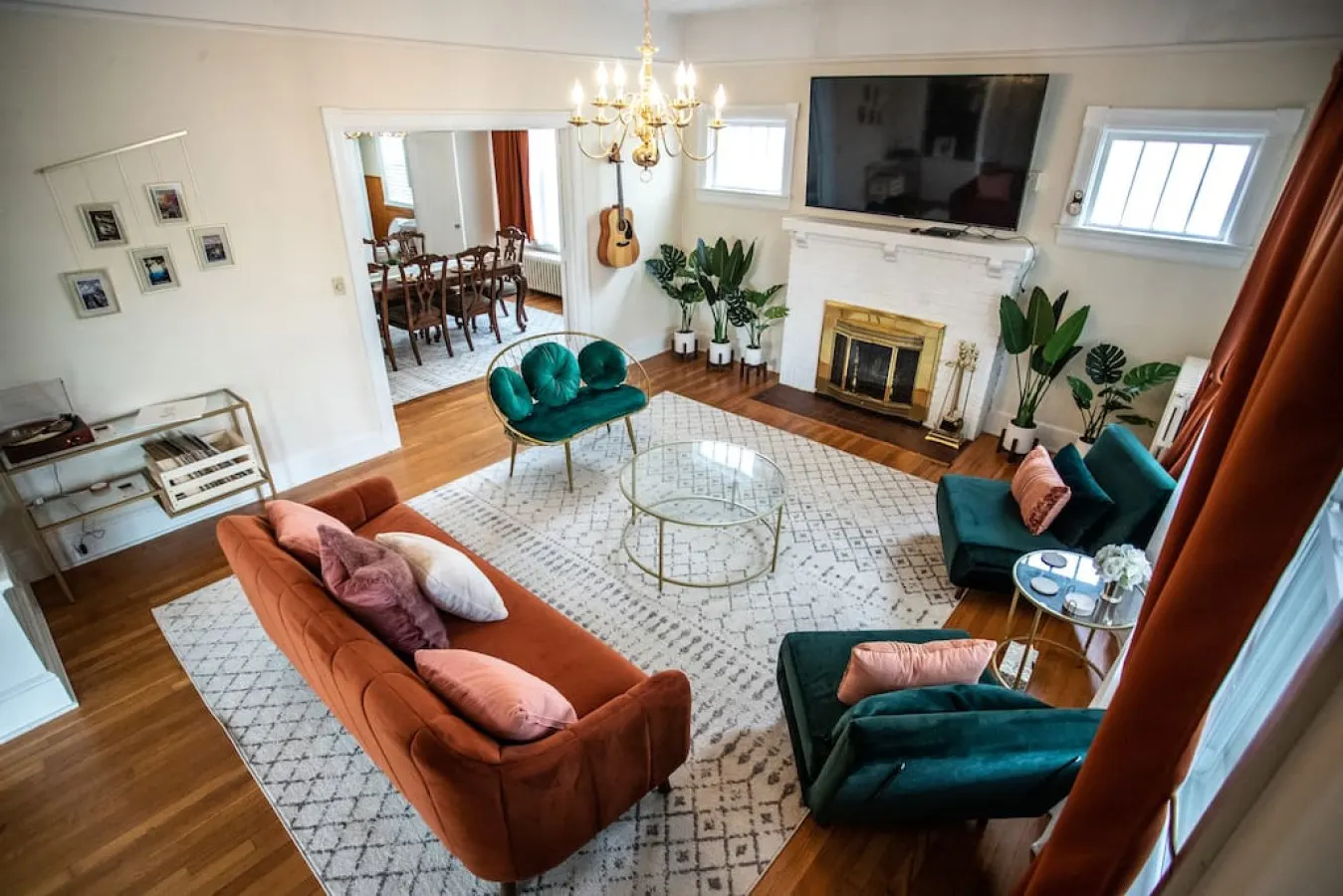 Living room with 75 inch TV, guitar,  vinyl record player, and French doors into the dining room