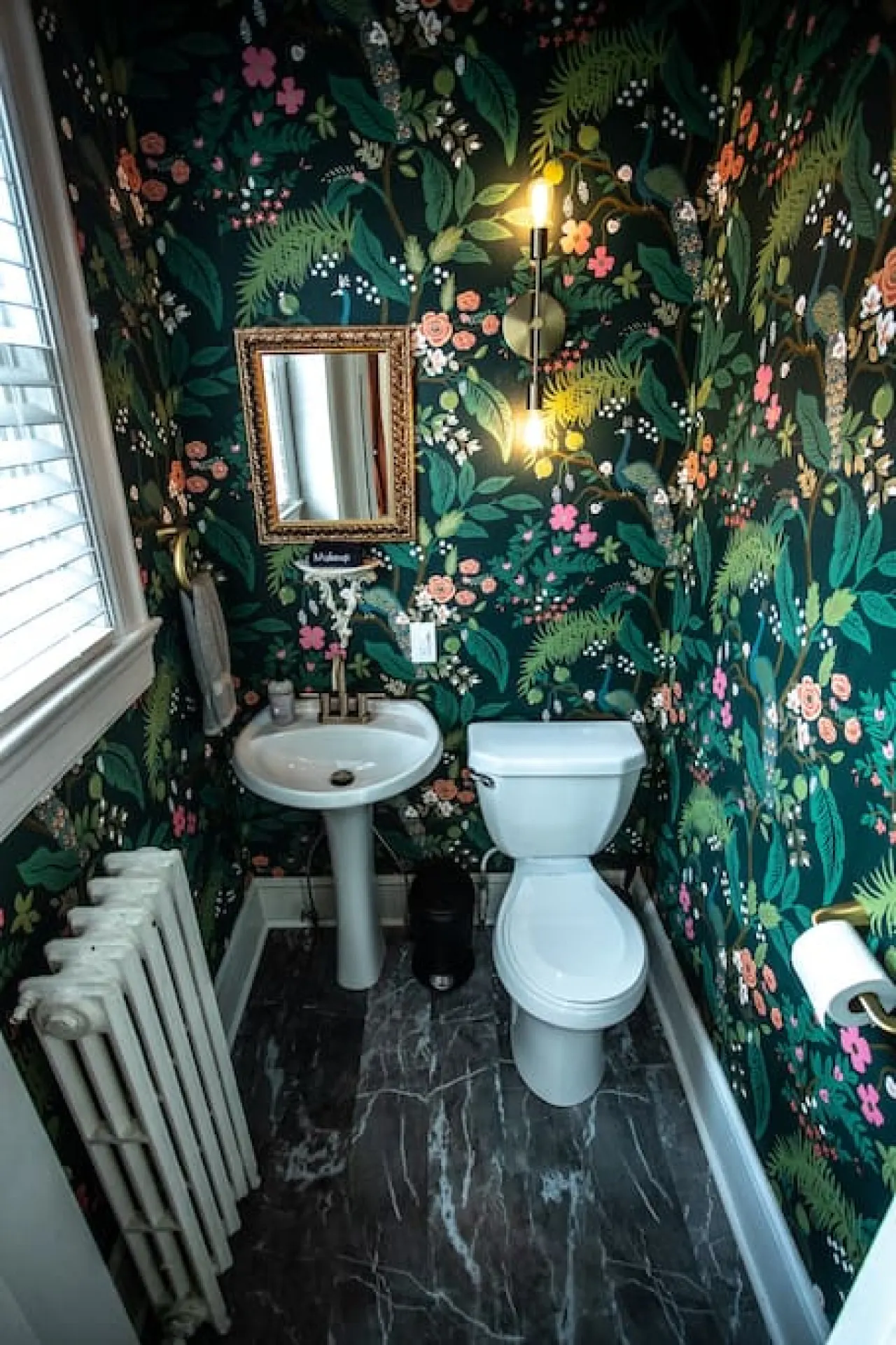 The half bath exemplifies the charm of the home. Vintage elements like the original overhead light, trim, and gold hardware mix will with our modern wallpaper, flooring, and sconce.