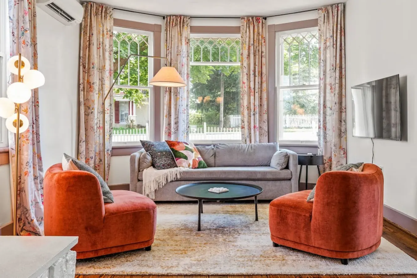 The living room is framed by a large bay window overlooking the street out front.