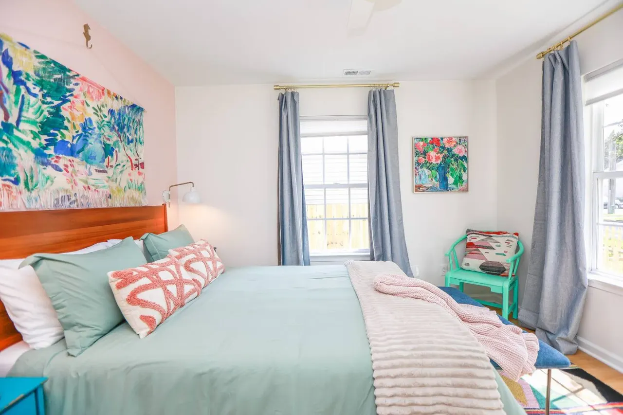 Primary suite with queen bed, desk area, and blackout curtains